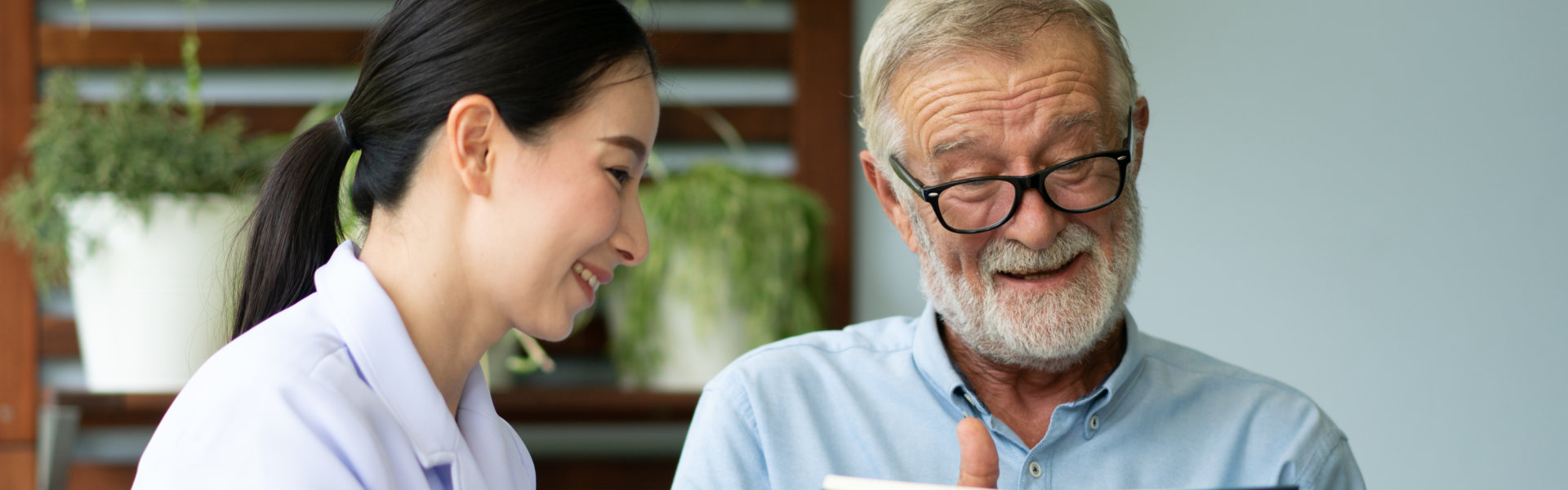 female caregiver with an elderly man smiling