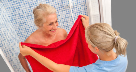 female caregiver helping an elderly woman bathing