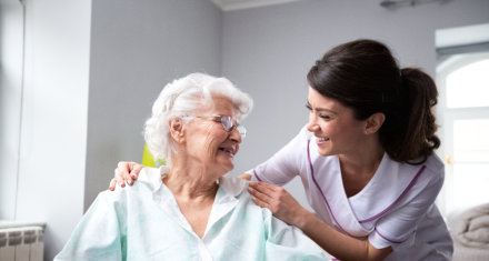 female caregiver smiling at an elderly woman