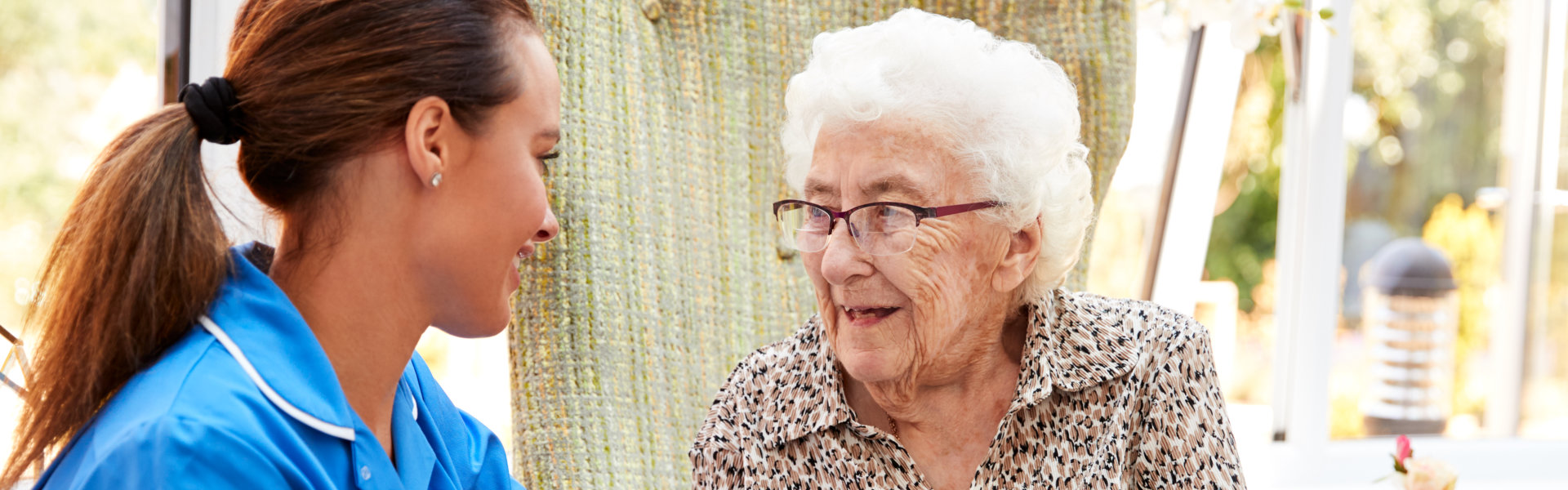 female caregiver talking to an elderly woman