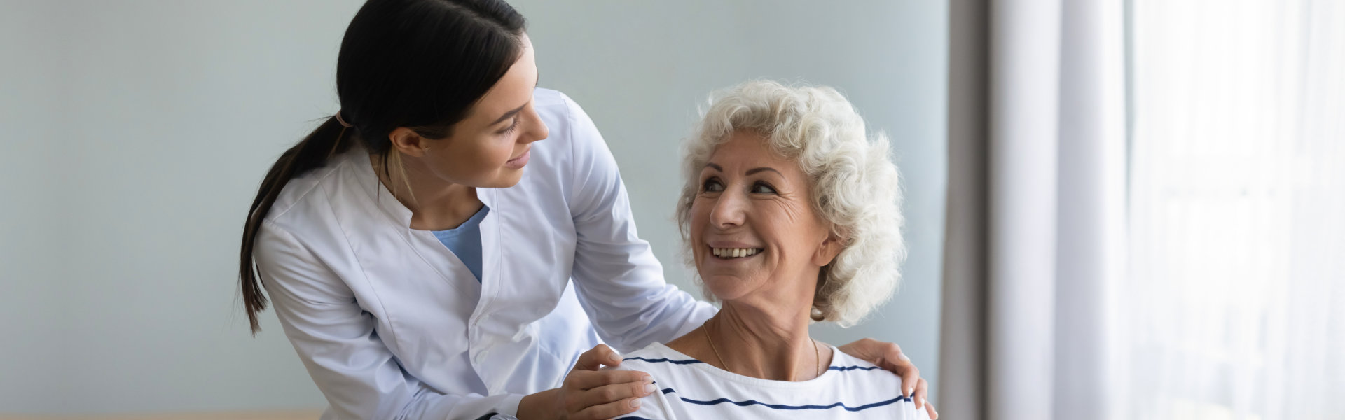 female caregiver smiling at an elderly woman