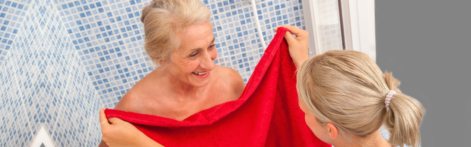 female caregiver helping an elderly woman bathing