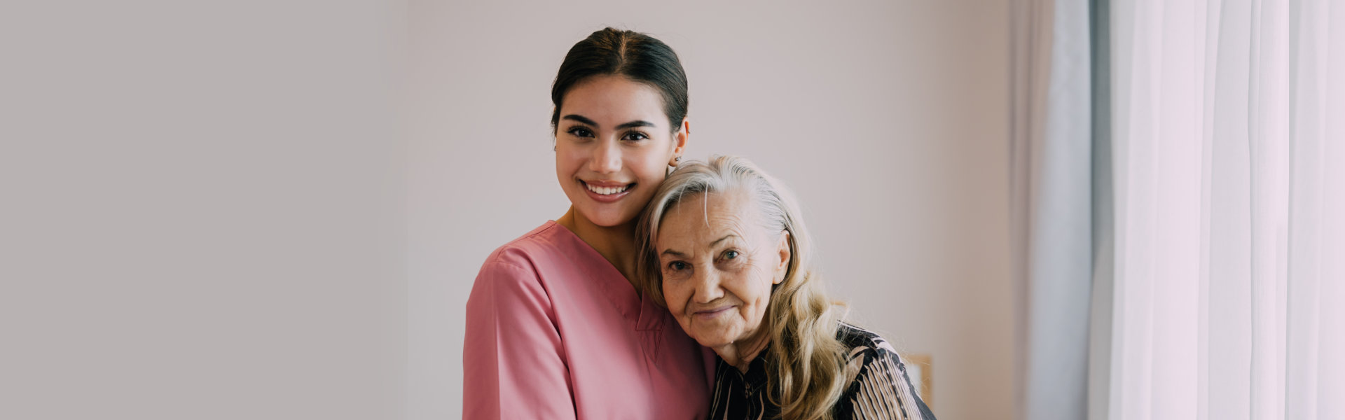 female caregiver with an elderly woman smiling