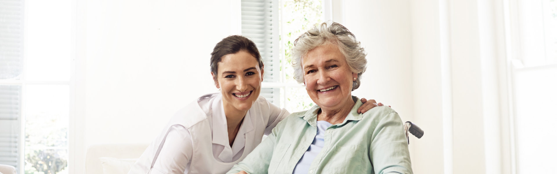 female caregiver with an elderly woman smiling