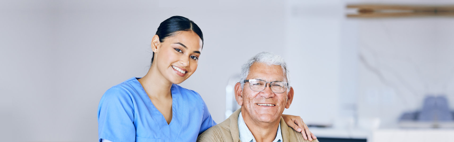 female caregiver with an elderly man smiling